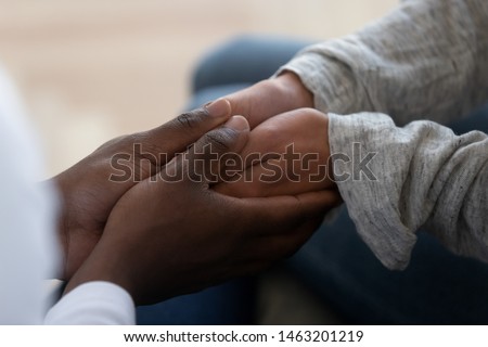 Mixed ethnicity family couple holding hands express support trust hope in marriage relationship, african black man friend husband give comfort compassion empathy to white woman wife, close up view