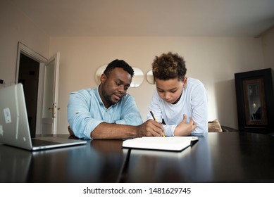 Mixed Family At Home. African Father And African American Child. Dad Helping Son With School Homework. Education And Relationship, Man Teaching And Boy Learning. Home Schooling.