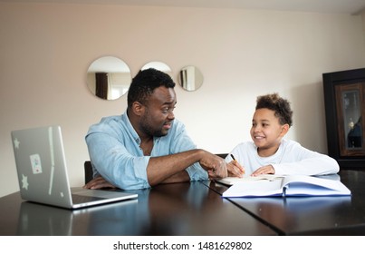 Mixed family at home. African father and african american child. dad helping son with school homework. Education and relationship, man teaching and boy learning. home schooling.