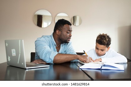 Mixed Family At Home. African Father And African American Child. Dad Helping Son With School Homework. Education And Relationship, Man Teaching And Boy Learning. Home Schooling.