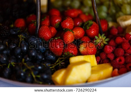 Mixed Fruit platter with fork strawberries blackberries pineapple and watermelon