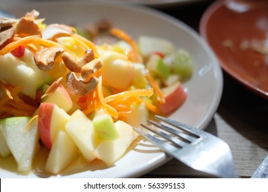 Mixed fruits salad with cashew nut with fork on white plate - Shutterstock ID 563395153