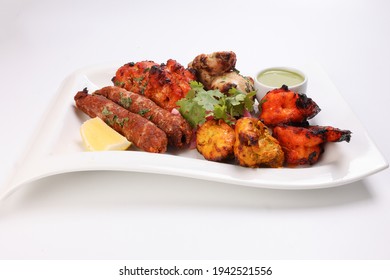 Mixed Grill Kebab Chicken Mutton Beef Prawn Fish Mint Sauce Lemon Pickled Onion Coriander On White Dish Over White Background