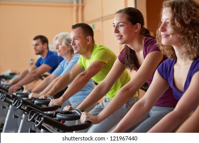 Mixed group riding bikes in spinning class in fitness center - Powered by Shutterstock