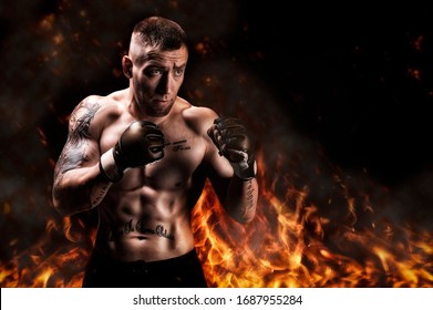 Mixed martial artist posing against the backdrop of fire and smoke. Concept of mma, ufc, thai boxing, classic boxing. Mixed media