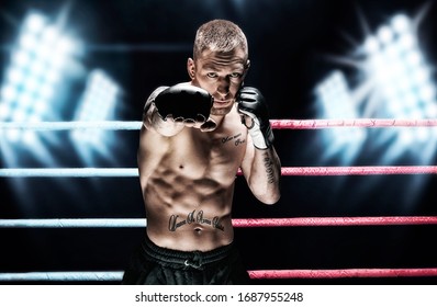 Mixed martial artist posing in the ring against spotlights. Concept of mma, ufc, thai boxing, classic boxing. Mixed media