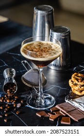 Mixed Mocha Coffee Flavored Rum Cocktail Served In Martini Glass With Homemade Chocolate Cookies On Black Marble Background. Rustic Cocktail Concept.