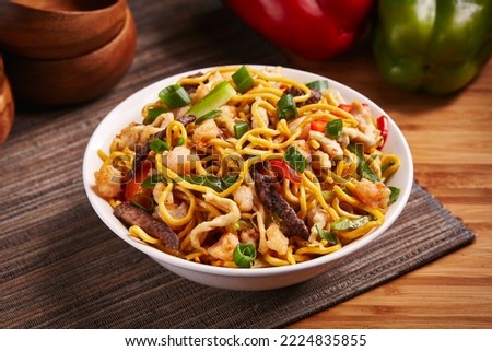 Mixed Noodles with vegetable, meat and chicken served in dish isolated on table side view of middle east food
