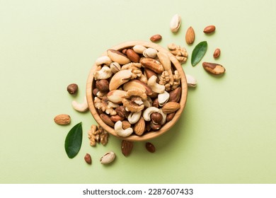 mixed nuts in bowl. Mix of various nuts on colored background. pistachios, cashews, walnuts, hazelnuts, peanuts and brazil nuts.