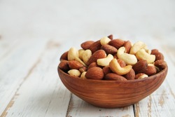 Mixed Nuts In A  Bowl On A White Wooden Background. 