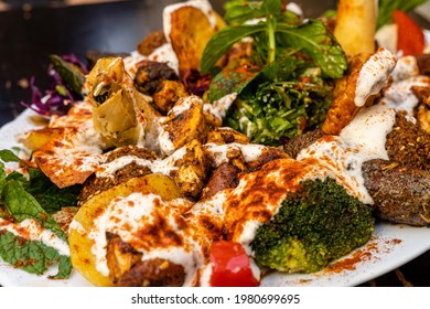 A Mixed Plate Of Arabic Lebanese Food Including Falafel, Halloumi, Makali, Merguez, Shish Taouk, Brocolli And Spring Rolls