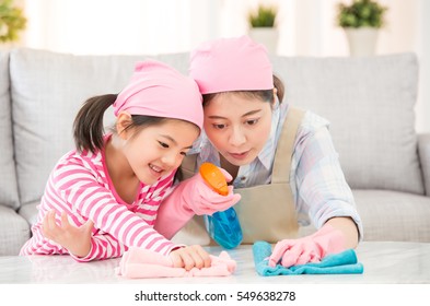 Mixed Race Asian Chinese Mother And Daughter Do The Cleaning In The House. Happy Family Cleans The Room. A Young Woman And A Little Child Girl Dusting. Family Housework And Household Concept.