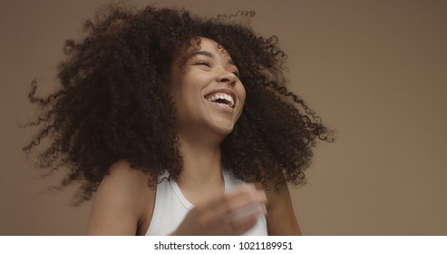 Mixed Race Black Woman Portrait With Big Afro Hair, Curly Hair In Beige Background. Natural Laughing