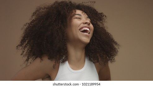 Mixed Race Black Woman Portrait With Big Afro Hair, Curly Hair In Beige Background. Natural Laughing