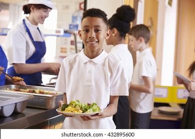 Mixed Race Boy Holding A Plate Of Food In A School Cafeteria