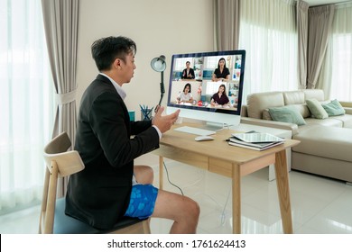 Mixed Race Businessman Wearing Formalwear Business Suit On Top And Boxer Pants On Bottom, Showing Other People On Screen In Formal Fridays Business Outfits Meeting Online In Living Room At Home.