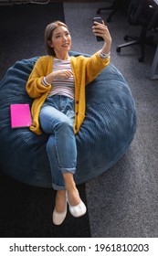 Mixed Race Businesswoman Chilling In Office Relaxing Space Lying In Beanbag. Independent Creative Design Business.