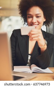 Mixed Race Busy Woman Using Credit Card For Shopping And Paying Bills On Line While Sitting In Coffee Shop