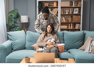 Mixed race couple African American man and white woman, male massage his girlfriend or wife in her menstrual period while sitting at home. Love, support and respect in relationship or marriage concept - Powered by Shutterstock