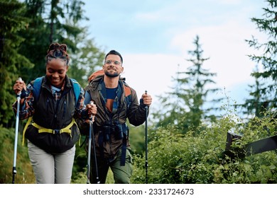 Mixed race couple hiking through the woods on rainy day. Focus is on man. Copy space. - Powered by Shutterstock