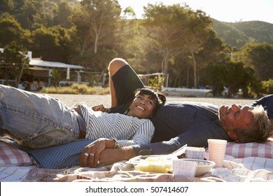 Mixed Race Couple Lying On The Beach Holding Hands, Ibiza