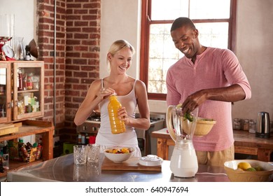 Mixed Race Couple Making Smoothies Together At Home