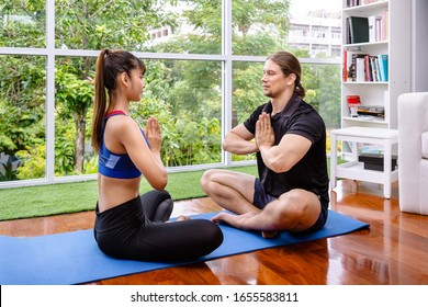 Mixed race couple meditating together in living room at home - Powered by Shutterstock