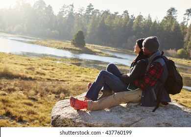 Mixed race couple on a rock in countryside admiring the view - Powered by Shutterstock