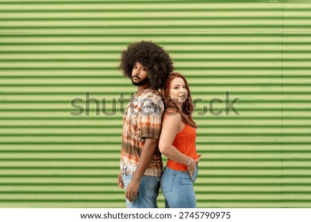 Mixed race couple posing side by side against green striped background