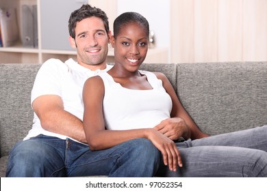 Mixed Race Couple Sat On Sofa