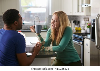 Mixed Race Couple Talking Over Breakfast In The Kitchen