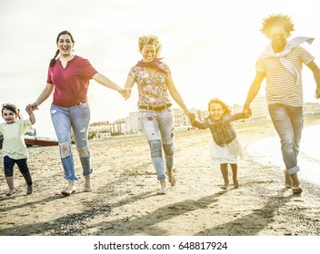 Mixed Race Family Friends Running And Having Fun On The Beach - Diverse Culture Parents And Children Enjoying Time Together - New Multi Ethnic Families And Travel Concept - Main Focus On Right People