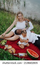 Mixed Race Family Having Picnic Outdoors Around River