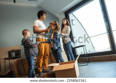 Mixed race family moving into their new home. They're carrying cardboard full of their accessories.	
 Photo stock © 