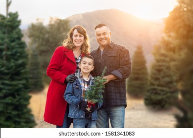 Mixed Race Family Outdoors At Christmas Tree Farm.