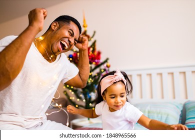 Mixed Race Family Spending Holiday In The Bed In Bedroom Christmas Morning