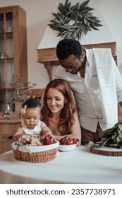 Mixed race family with white son infant swarthy daughter spend time together morning. African american man with his fair skinned wife kids enjoy healthy vegan food in positive emotion at table home - Shutterstock ID 2357738971