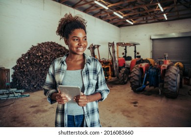Mixed race female standing in farm store room organising layout using digital tablet  - Powered by Shutterstock