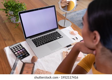 Mixed race gender fluid man making makeup vlog using laptop with copy space screen. staying at home in isolation during quarantine lockdown. - Powered by Shutterstock