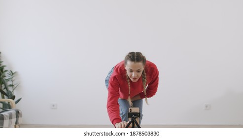 Mixed Race Girl Start Recording Dance Moves At Camera In Front Of White Wall Background. Social Media Concept