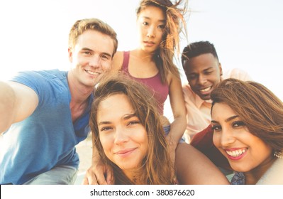 Gemischte Rennen Gruppen von Freunden, die am Strand von Santa Monica spazieren und Selfies machen