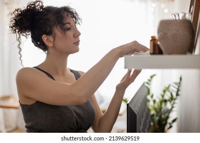 Mixed Race Housewife Cleaning Shelf With Hygge Decor Elements Vinyl Plate Vase Picture Dust Off With Rag. Adorable Curly Female Clean Wiping Wooden Surface Furniture At Home Living Room Apartment