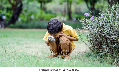 Mixed race little boy exploring the nature with magnifying glass outdoors, children playing in the park with magnifying glass. Curious kid exploring nature by magnifier - Powered by Shutterstock