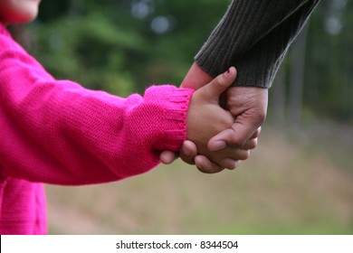 A Mixed Race Mother And Daughter Holding Hands