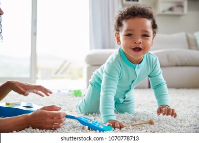 Mixed race mum and toddler son playing at home, close up