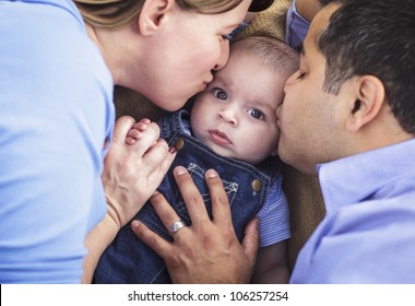 Mixed Race Parent Kissing Their Son Together.