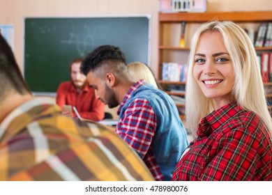 Mixed Race Students Group With Professor Sit Desk University Classroom, Beautiful Blonde Young Girl Wear Checked Shirt Looking Camera Happy Smiling