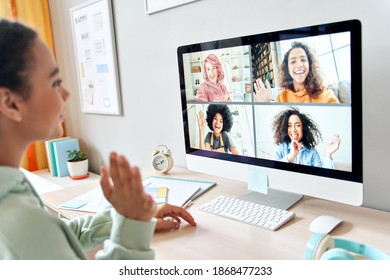 Mixed Race Teen Girl Waving Talking To Happy Diverse Teenage Friends During Online Virtual Chat Video Call In Group Conference Distance Chat Virtual Meeting Using Computer At Home. Over Shoulder View.