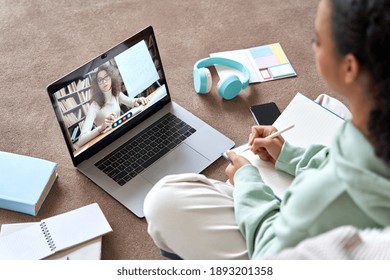 Mixed Race Teen School Girl College Student Distance Learning Virtual Distance Online Lesson On Video Call With Teacher Tutor Studying At Home. Elearning Digital Class On Computer Sitting On Floor.