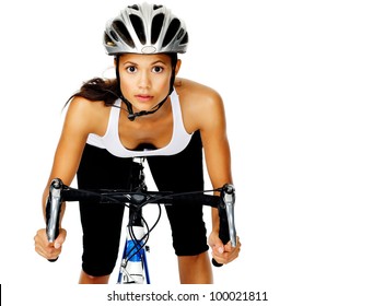 Mixed race woman concentrates with a serious face, wearing a helmet on a bicycle